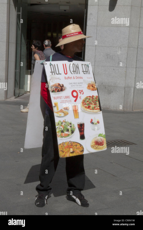 man-carrying-advertising-sandwich-board-of-food-menu-sign-in-madrid-C90N1W.jpg