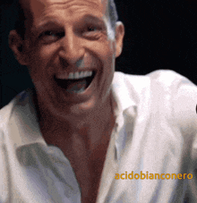 a man in a white shirt is laughing with the words acidobianconero written on the bottom