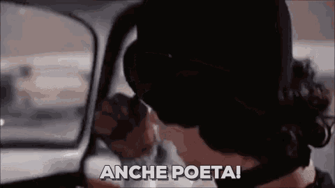 a man wearing a mask is driving a car and saying anche poeta !